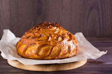 Traditional savory pie kurnik with chicken, potatoes and rice on parchment. Homemade baking. © elenarui