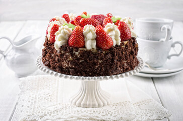 Traditional German strawberry cheese cake with fresh fruits and chocolate crumbles served as close-up on a cake plate