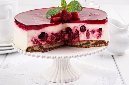 Traditional German cheesecake with cherry and raspberry served as close-up on a cake plate