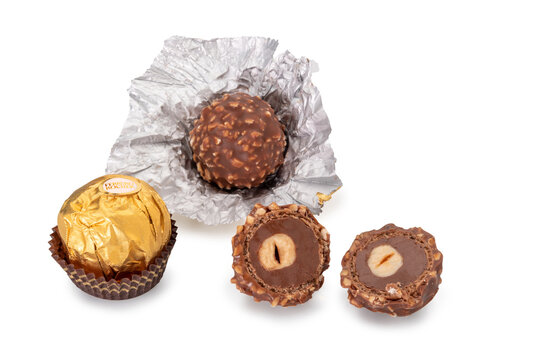 Alba, Italy - december 25, 2022: Ferrero Rocher isolated on white, chocolate wrapped in golden paper with crunchy wafer shell and chopped hazelnut filled with hazelnut and chocolate, clipping path