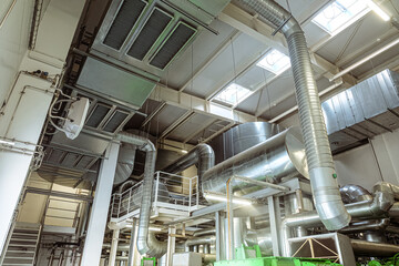 Galvanized round and rectangular ventilation gas ducts in an industrial building. Engineering air system.