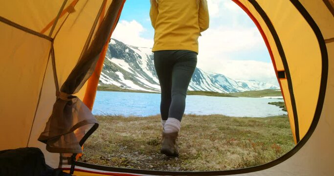 Woman, photographer and camping in tent by mountain, lake and relax in nature for wellness hiking holiday. Travel freedom, outdoor Norway getaway and camper taking photograph of landscape with camera