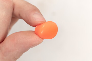 Human silicone earplugs hold fingers on white background