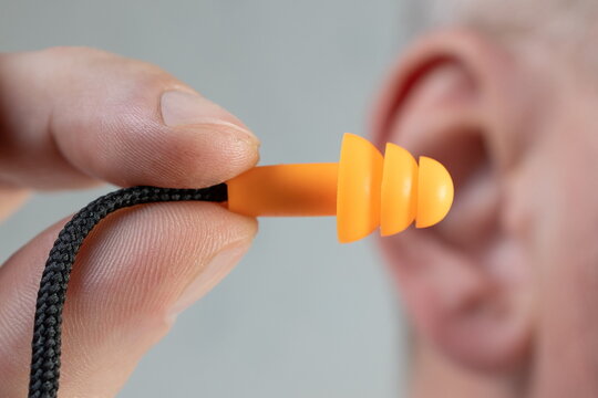 Human silicone earplugs hold fingers on white background