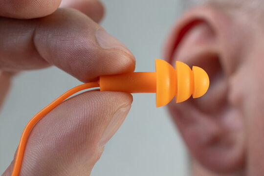 Human silicone earplugs hold fingers on white background