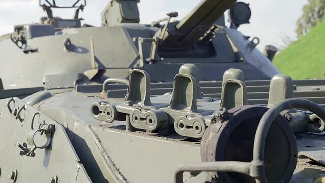 Front headlight with battle tank protection. Very bright searchlight on the tank turret, close-up. Armored infantry fighting vehicle. Fragment of an old armored personnel carrier, khaki headlight.