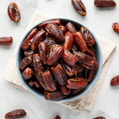 Pitted Organic Dates in Bowl on gray background, top view. Flat lay, overhead, from above.