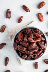 Pitted Organic Dates in Bowl on gray background, top view. Flat lay, overhead, from above.