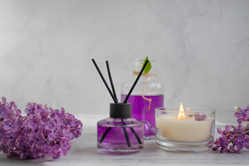 Obraz na płótnie Canvas Perfume for home, lilac flower, candle on a light background