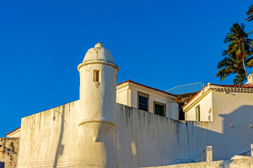 Fototapeta na wymiar Walls and guardhouse of an old colonial fortification in the city of Salvador in Bahia illuminated by the sunset