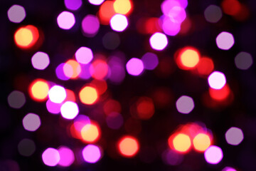 Blurred yellow, white, red, blue, purple and orange lights on black background