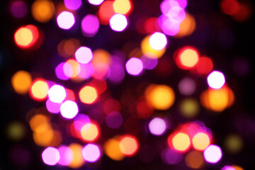 Blurred yellow, white, red, blue, purple and orange lights on black background