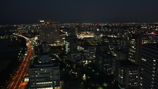 FUKUOKA, JAPAN - NOVEMBER 2022 : Aerial high angle view of Fukuoka City in sunset. Time lapse shot, dusk to night. View around Tenjin and Nakasu downtown area. Travel and city life concept video.