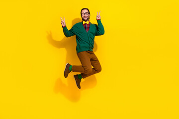 Fototapeta na wymiar Full length photo of excited crazy man jumping demonstrate v-sign isolated on yellow color background