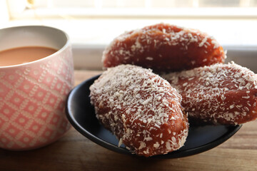 cup of coffee and koesisters. Traditional Cape Malay South African snack. Fried dough dipped in syrup 