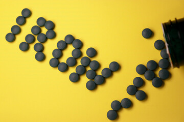 close up of green iron vitamin pills on yellow background
