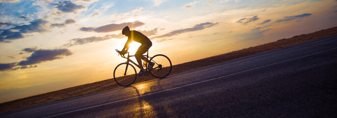 Fototapeta na wymiar Young sports man cycling with bicycle on the road in summer 
