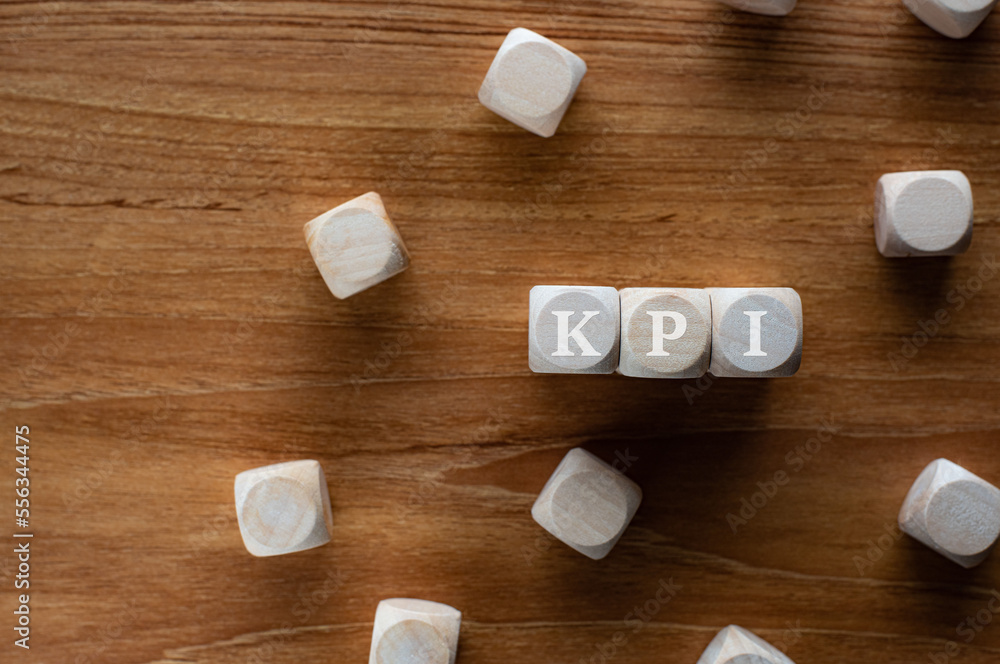 Poster there is wood cubes with the word kpi. it's an abbreviation for key performance indicator.