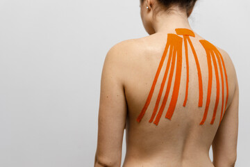 Female athlete on white background with tapes on her back 