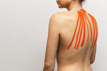 Female athlete on white background with tapes on her back 