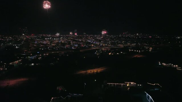 Dolly forward through city during fireworks.