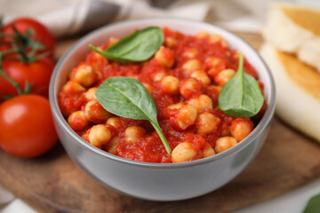 Delicious chickpea curry served on wooden board, closeup