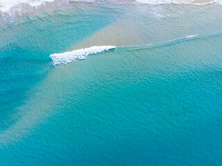Obraz premium Beautiful sea waves water surface,Beach Sand Sea Shore and waves white foamy summer sunny day background.Amazing beach top down view overhead seaside nature background