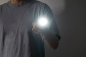 man holding an electric light torch in the dark space