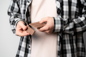 person holding and braking black chocolate bar