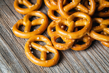 Salty mini party pretzels on a wooden surface close-up.