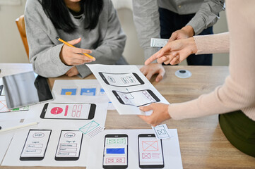 Team of professional mobile application developers checking and testing their new prototype