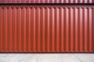 Red steel cargo containers stacked on concrete floor. Industrial background