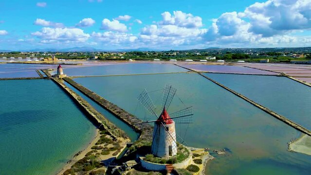 old windmill with Salt Pans near Marsala in Sicily, Italy in Europe on a sunny day