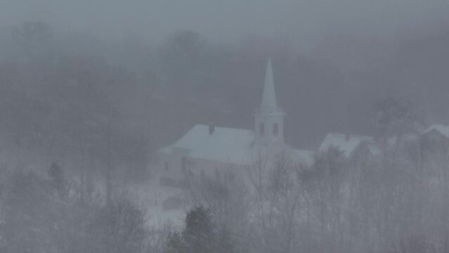 Monson community church seen through heavy snowfall low visibility