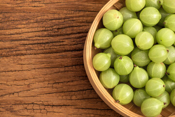 Indian Gooseberry fruits on wooden background.