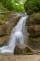 A mountain river in a natural channel with rapids and waterfalls.