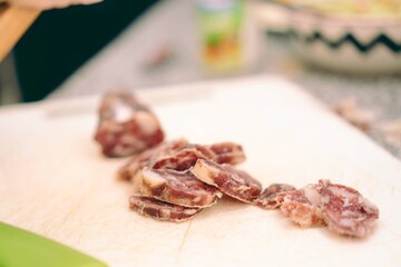 Chopped salami placed on the chopping board on top of the kitchen counter.