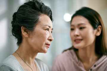 young asian daughter comforting elderly mother - Powered by Adobe