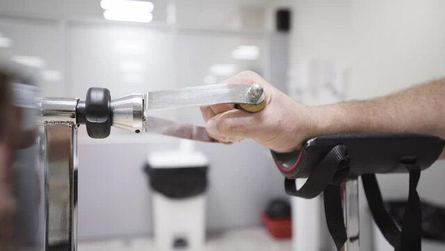 caucasian male hand close up doing exercises at private clinic for wrist at a medical device, kinetotherapy device