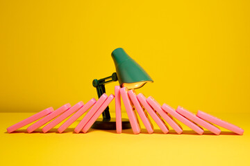 Green toy lamp failing on stoping domino effect of pink domino