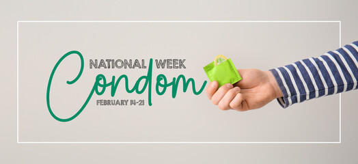 Male hand with condom on grey background. National Condom Week