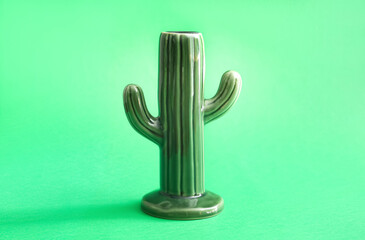 Ceramic cactus on green background