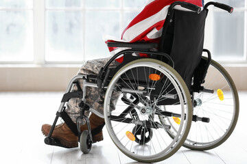 Fototapeta premium Young soldier in wheelchair with USA flag at home