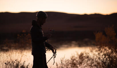 silhouette of a male climber in a helmet against the background of the Ili River in the tamgaly-tas...
