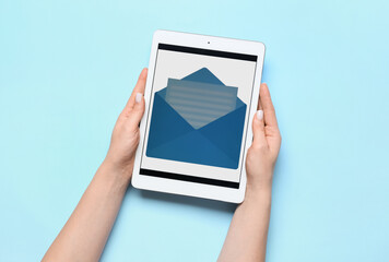 Woman holding tablet computer with new unread message on color background