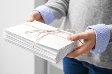 Woman holding tied letters, closeup. Mail concept