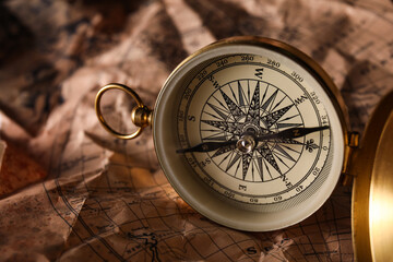 Golden compass on world map, closeup
