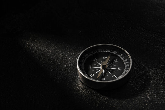 Black compass on dark background