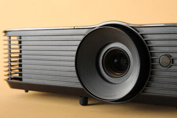 Black video projector on beige background, closeup
