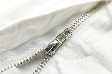 Closeup view of metal zipper on white clothes